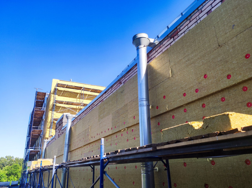 Утепление кирпичного фасада минераловатными плитами на строительных лесах с водосточными трубами