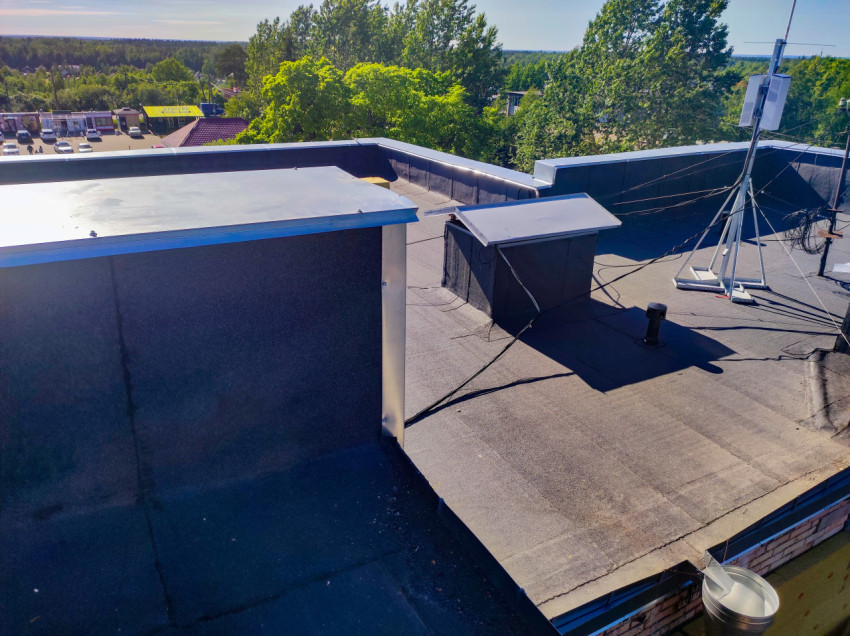 Антенная мачта с кабелями и кровельные короба на плоской крыше