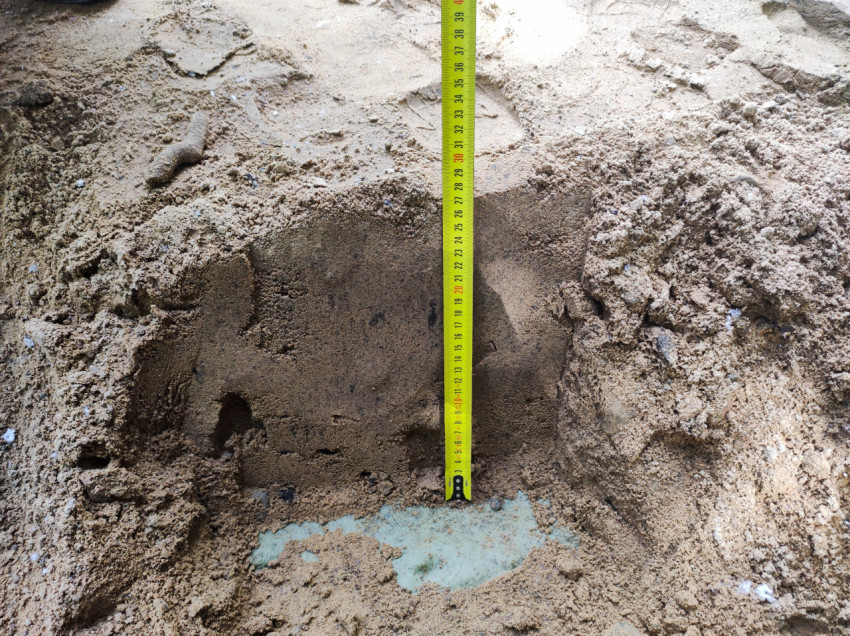 Рулетка в песчаной выемке для контроля толщины основания под покрытие