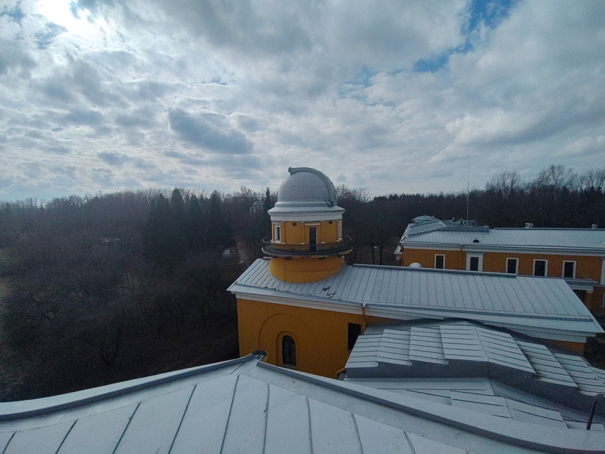 Здание обсерватории с куполом на фоне облачного неба