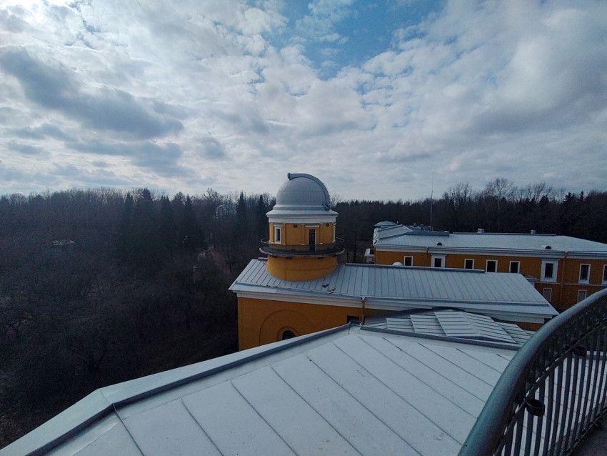 Астрономическая обсерватория с куполом телескопа на фоне облачного неба