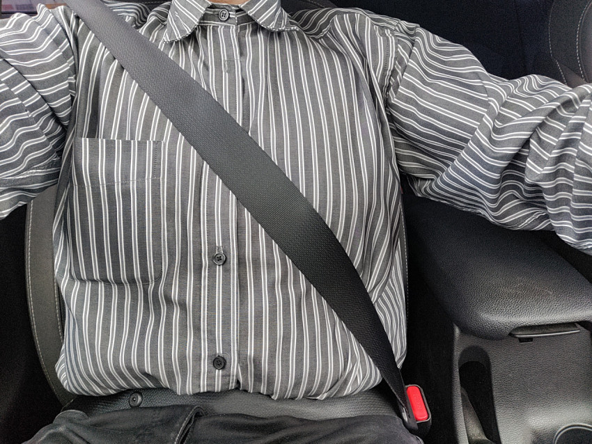 Водитель с пристёгнутым ремнём безопасности в движущемся авто