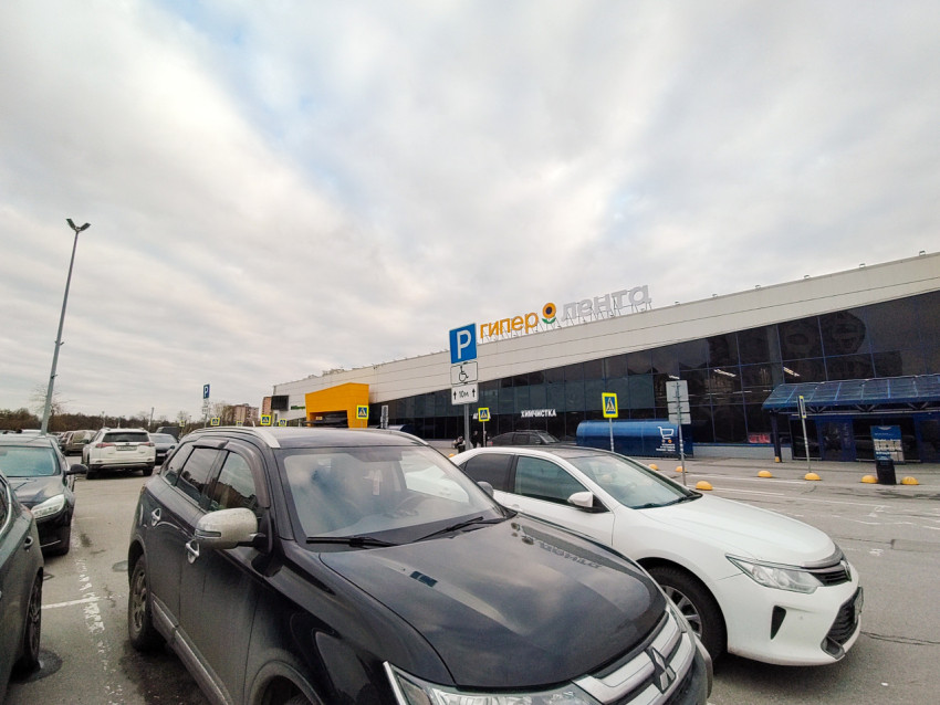 Фасад гипермаркета и парковочная зона с указателями для маломобильных водителей