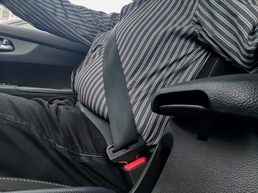 Ремень безопасности, застёгнутый на водителе в салоне автомобиля