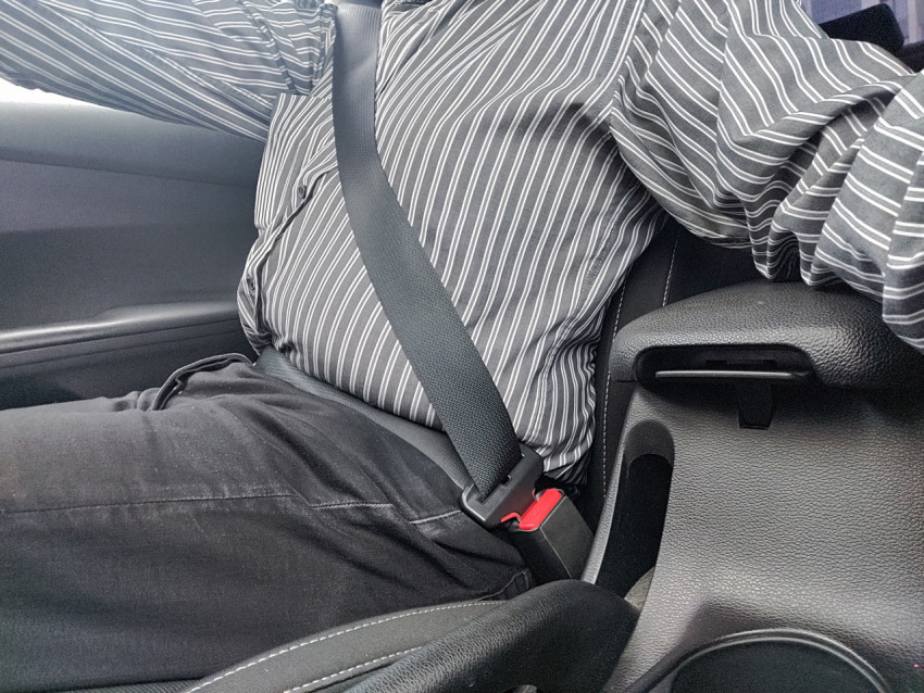 Сидящий в автомобиле водитель с ремнём безопасности