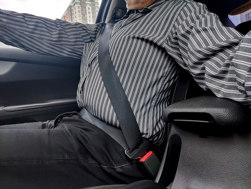 Ремень безопасности, закреплённый на водителе в движущемся автомобиле