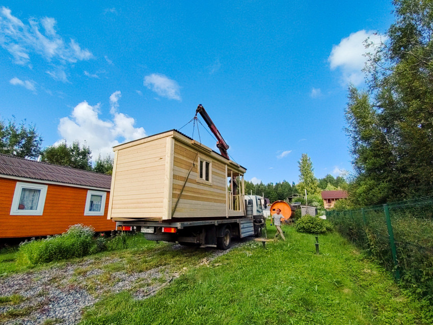 Грузовик с краном-манипулятором доставил деревянный модульный дом на дачный участок