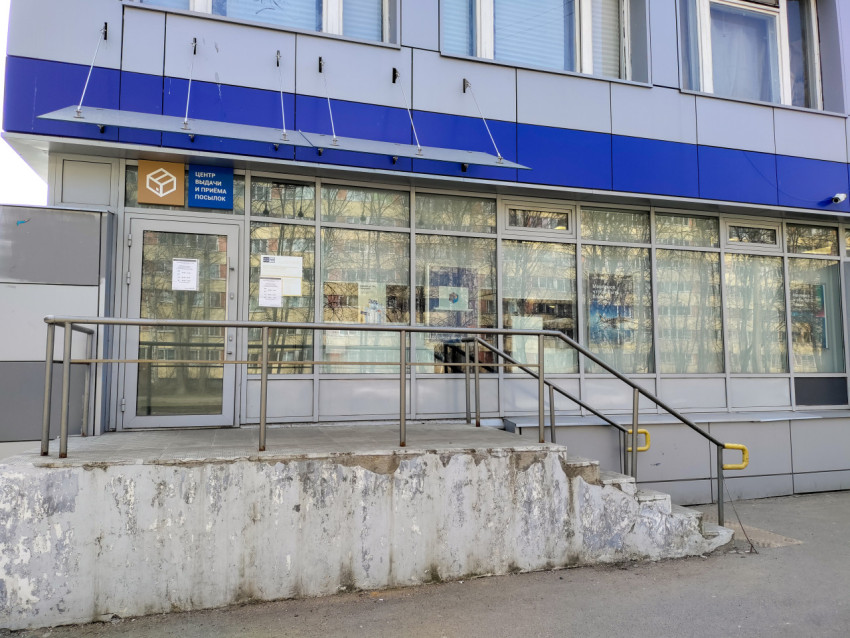 Вход в центр выдачи и приёма посылок на фоне жилого массива