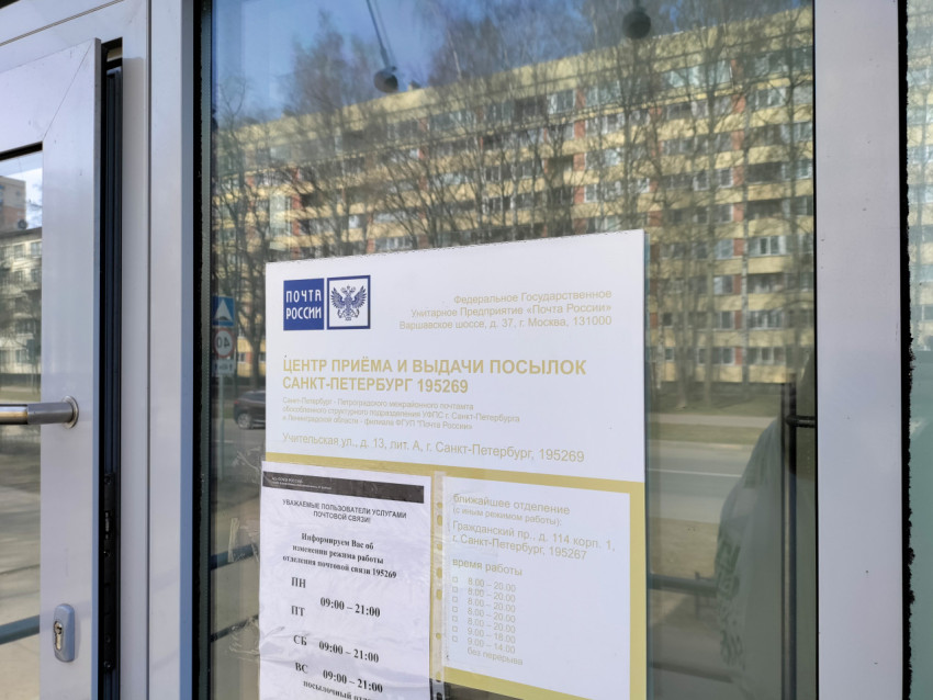 Объявление с расписанием работы почтового отделения на стеклянной двери