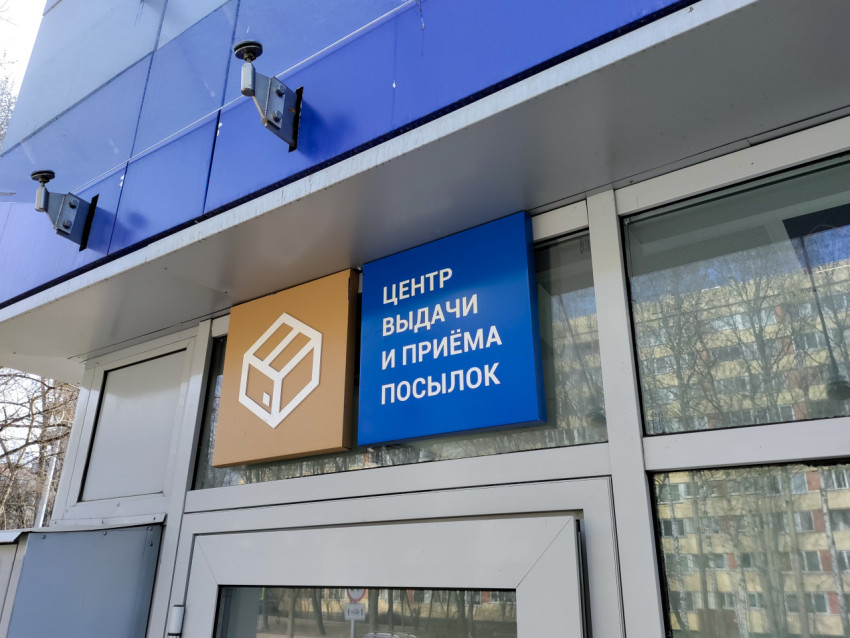 Вывеска центра выдачи и приёма посылок Почты России на фасаде здания