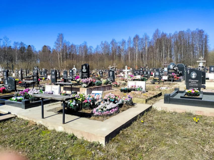 Обширное кладбище с надгробиями и венками весной