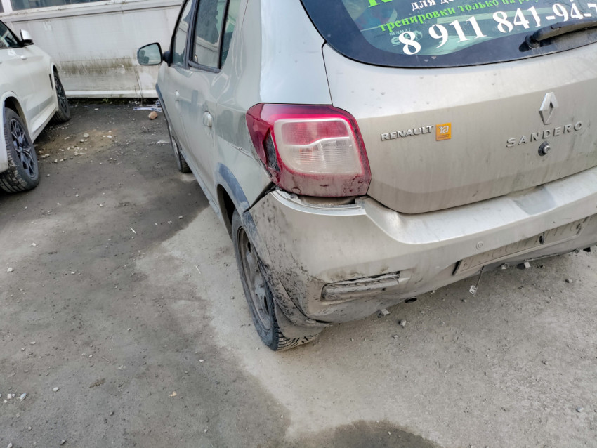 Задняя часть грязного автомобиля Renault Sandero на парковке