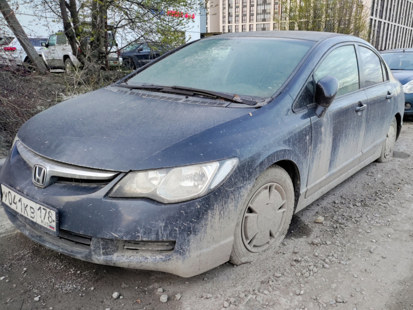 Грязный седан Honda, припаркованный на обочине