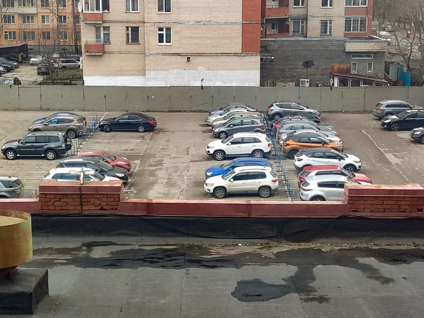 Автомобили, припаркованные на открытой стоянке у жилого дома