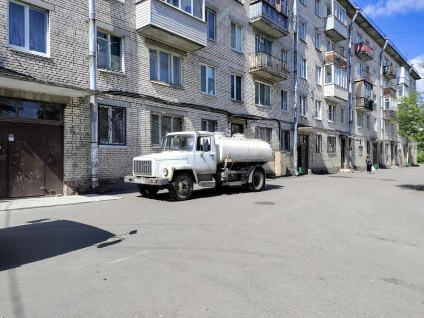 Автоцистерна во дворе кирпичной пятиэтажки