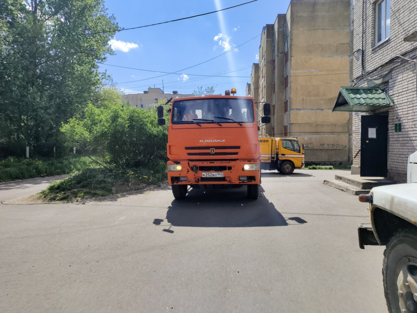 Коммунальный КамАЗ с вакуумной цистерной во дворе, фронтальный вид