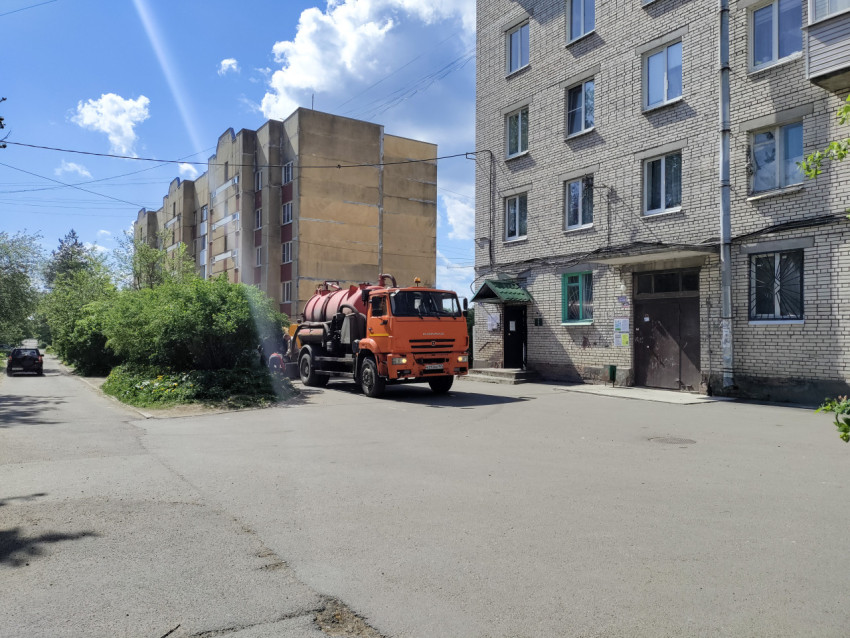 Вакуумная спецмашина у подъезда кирпичного дома