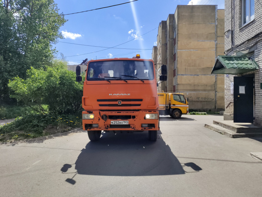 Фронтальный крупный план КамАЗа коммунальной службы во дворе