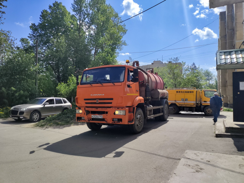 КамАЗ-ассенизатор с цистерной на повороте у подъезда