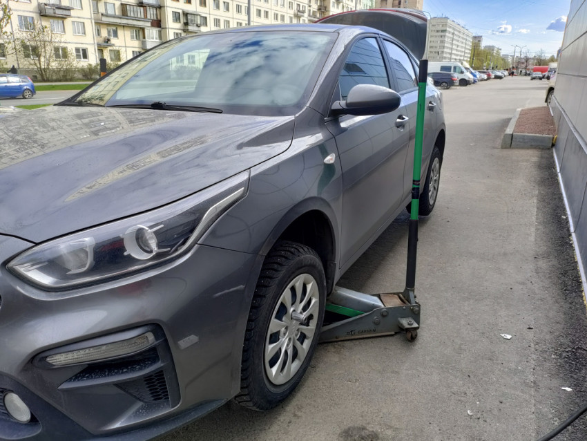 Kia на подъемнике перед зданием