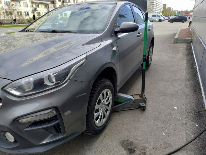 Автомобиль Kia во время ремонта на домкрате