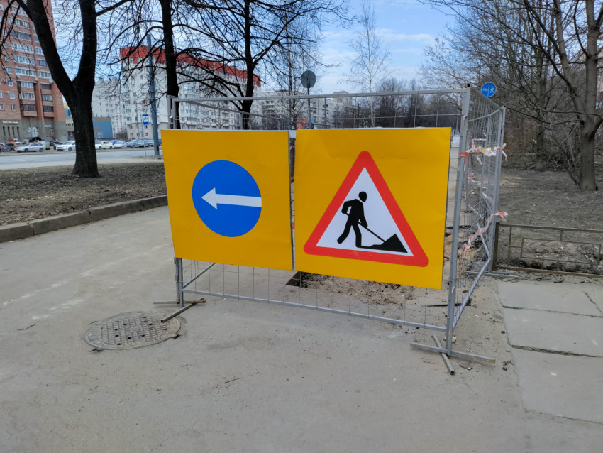 Ограждение с дорожными знаками на тротуаре во время ремонта