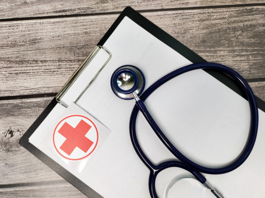 Медицинский стетоскоп и планшет с символом красного креста