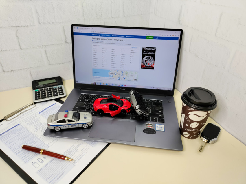 Модели автомобилей и ноутбук Huawei на офисном столе