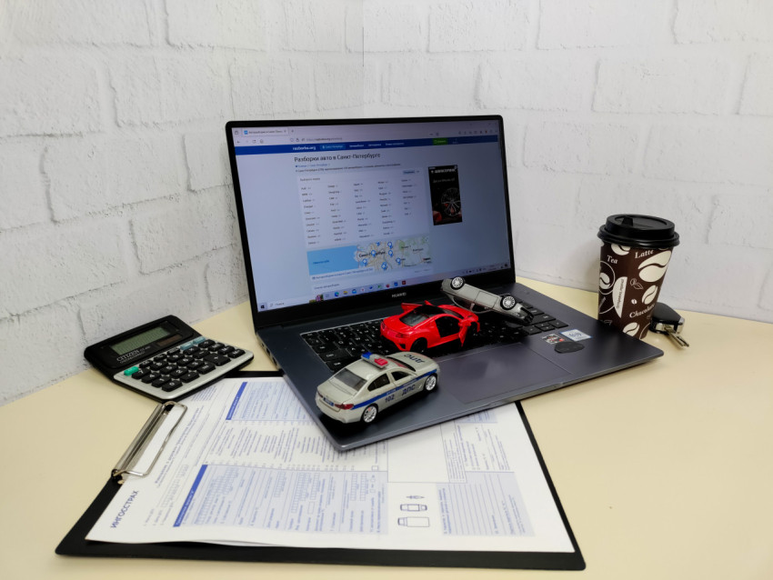 Модели автомобилей и калькулятор на рабочем столе с ноутбуком