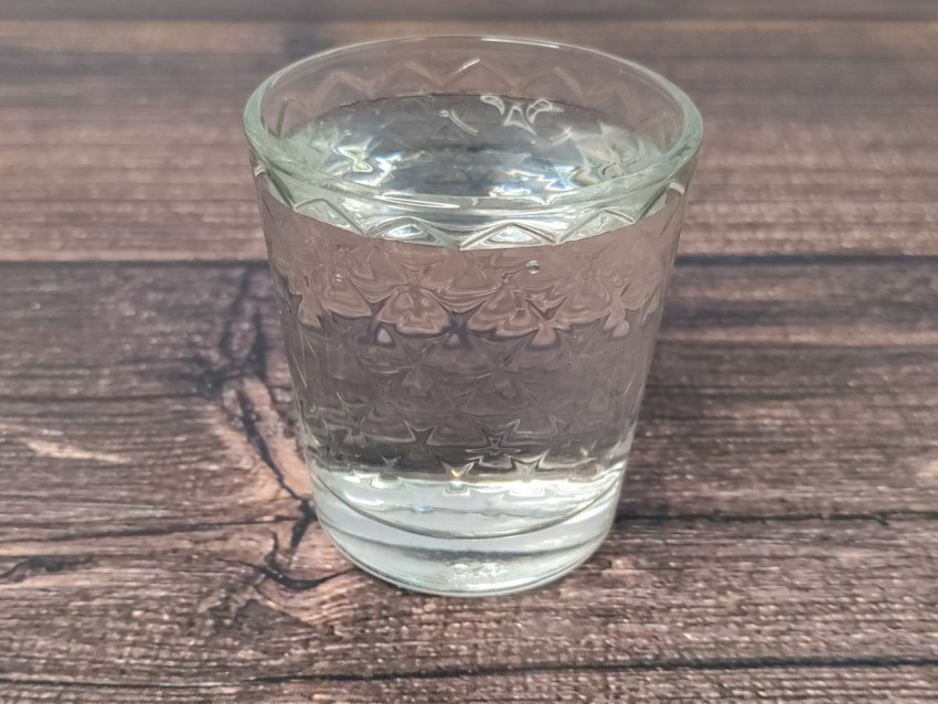 Стопка водки на деревянном столе