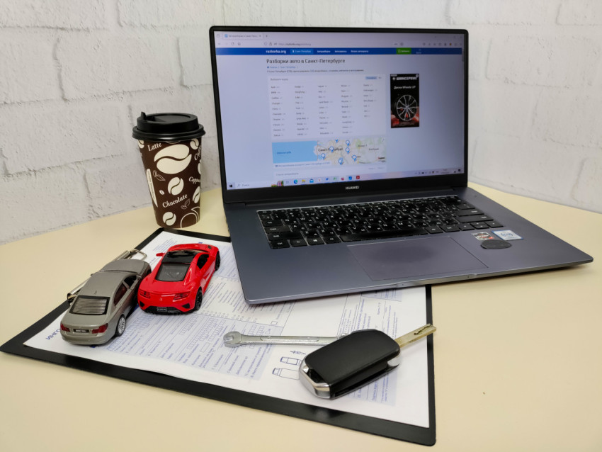 Модели машин и ноутбук Huawei на фоне документов и кофе