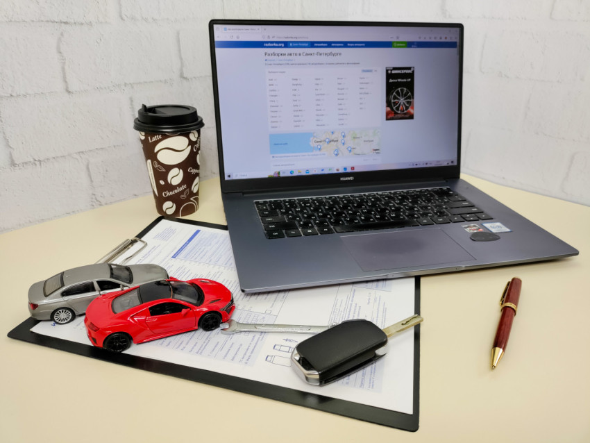 Офисная сцена с моделями автомобилей и ноутбуком Huawei