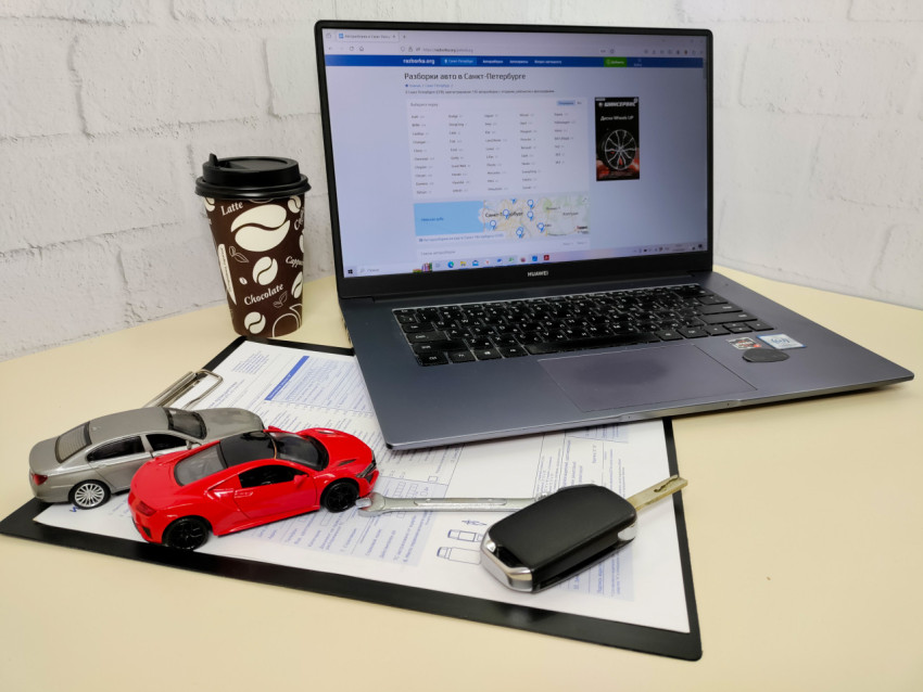 Рабочий стол с ноутбуком, документами и моделями автомобилей