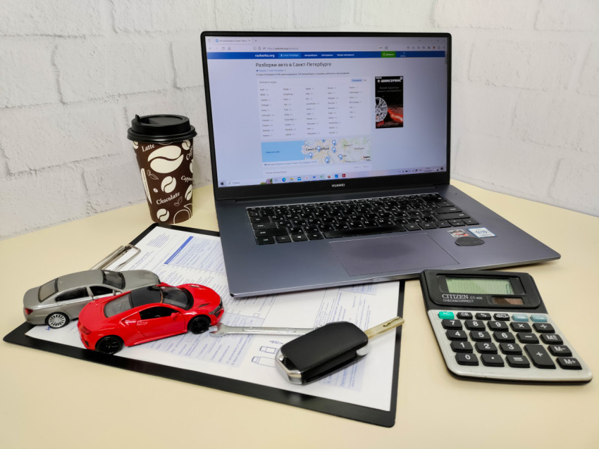 Рабочий стол автоэксперта с ноутбуком и модельными автомобилями
