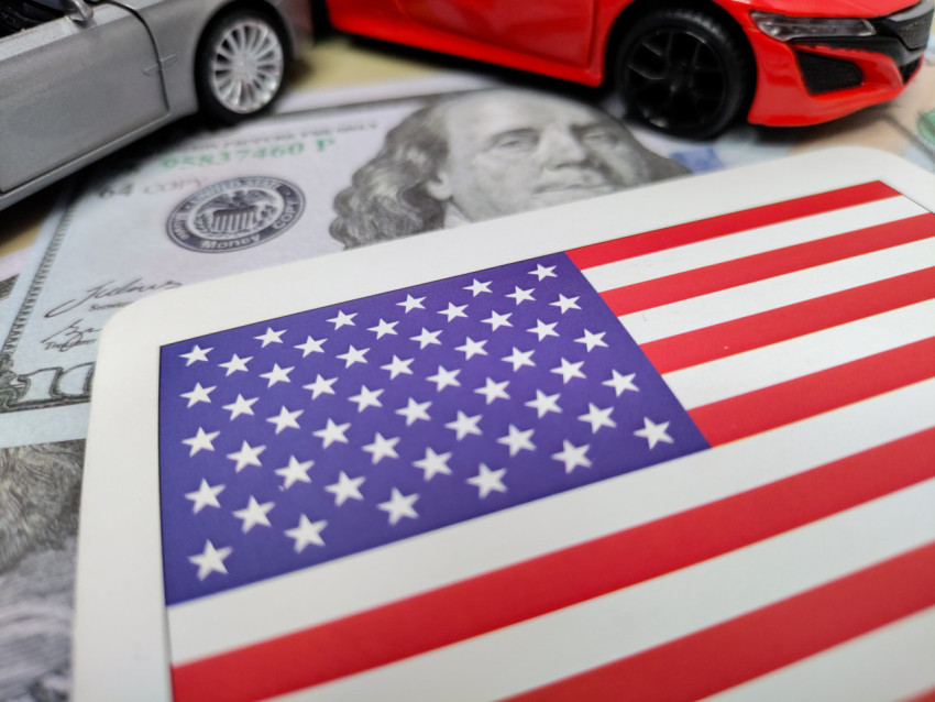 Американский флаг, автомобили и доллары в контексте экономики США