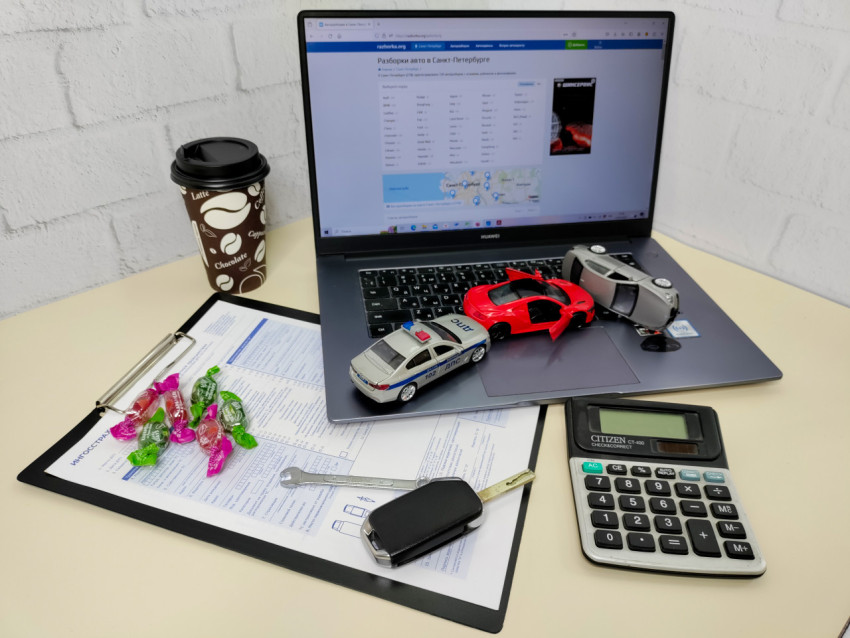 Модели автомобилей и ноутбук с сайтом автозапчастей на рабочем столе