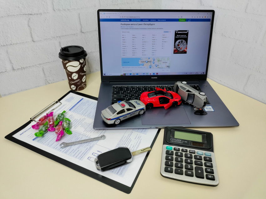 Игрушечные автомобили и документы по страхованию на фоне ноутбука