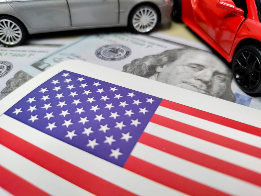 Флаг США, доллары и автомобили, отражающие промышленную мощь страны