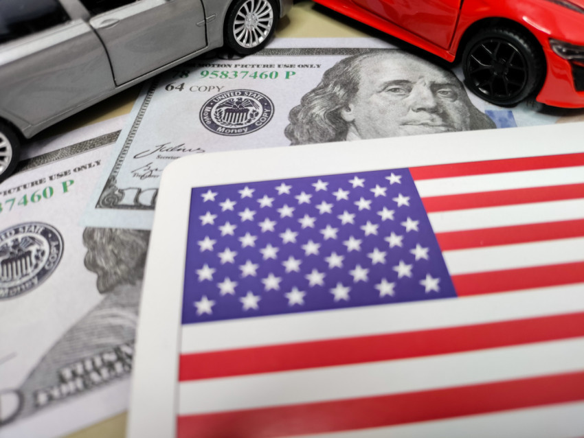 Флаг США и модели машин на фоне портрета Бенджамина Франклина