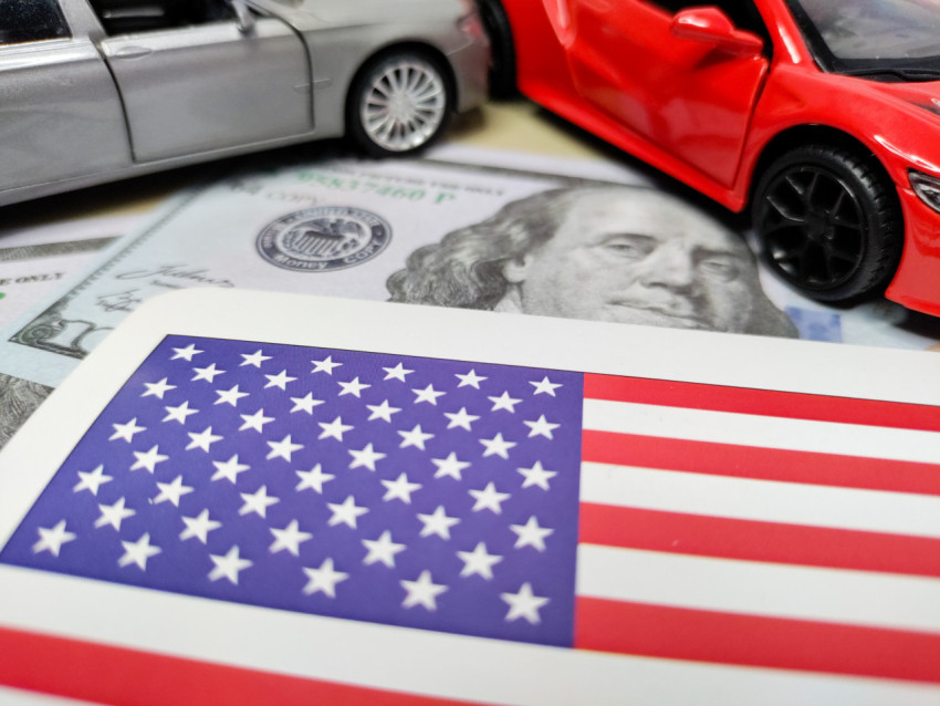 Американский флаг и модели автомобилей на долларовых купюрах