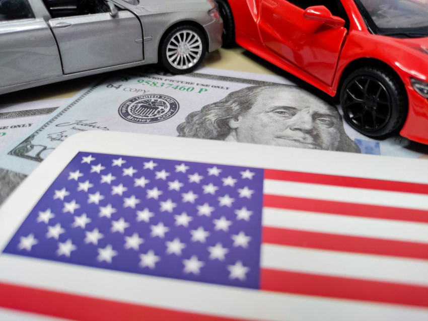 Флаг США, банкноты и миниатюрные автомобили крупным планом