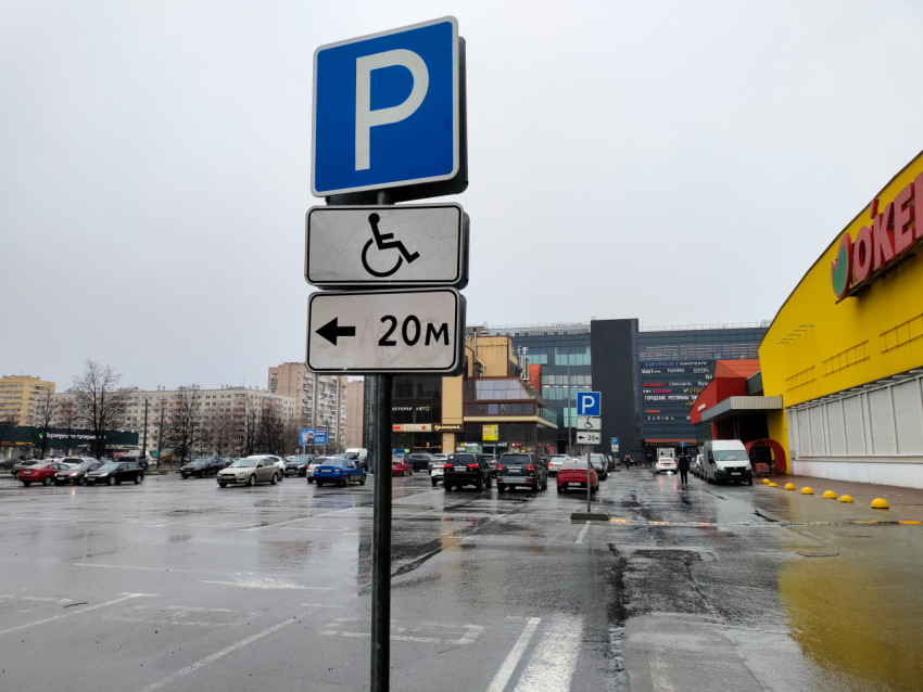 Парковочный указатель у торгового центра на фоне жилой застройки