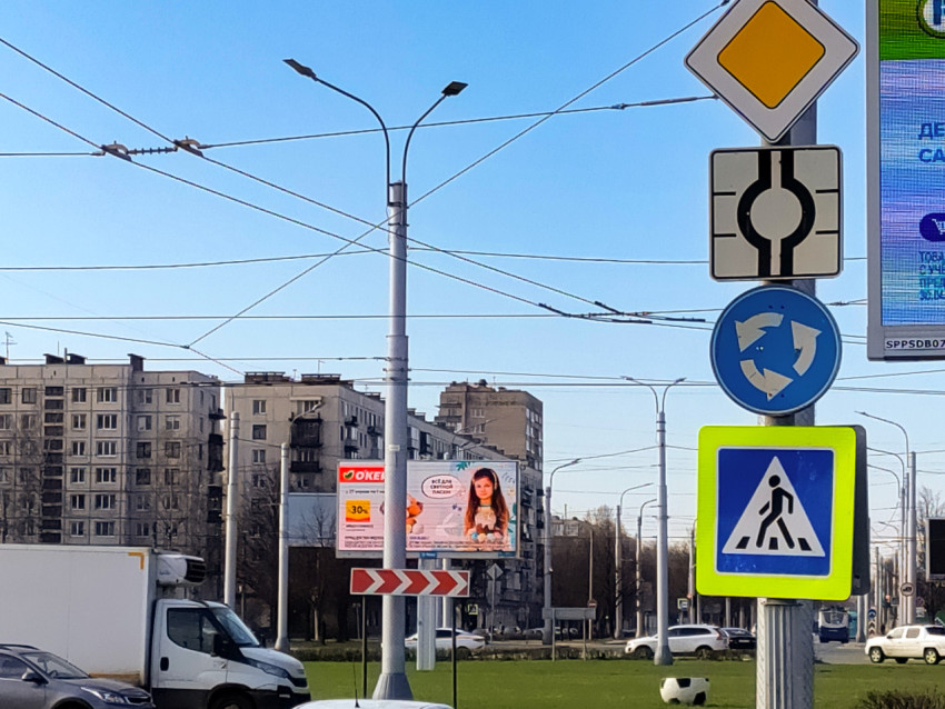 Дорожные знаки и жилые дома на фоне городской улицы