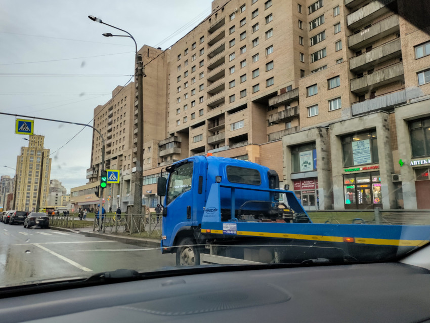 Эвакуатор на фоне жилого массива в городской среде