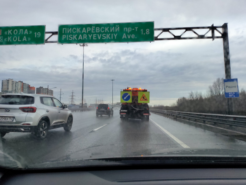 Дорога с дорожными указателями и спецтехникой на участке трассы в Санкт-Петербурге