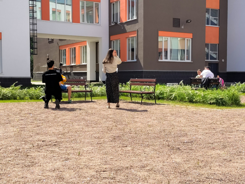 Съёмочный процесс во дворе школы с оператором и участниками