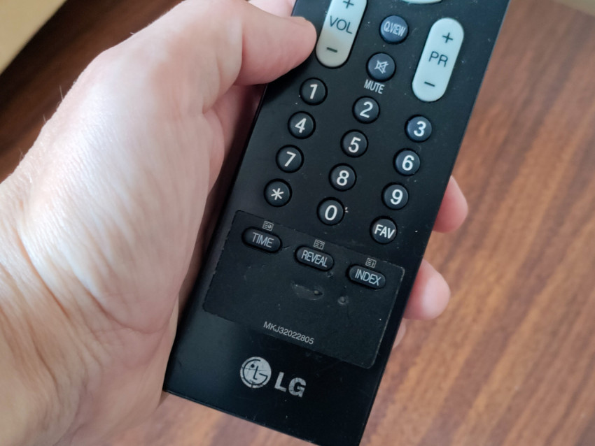 Пульт LG в руке пользователя с нижним блоком кнопок