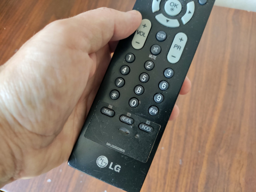 Пульт LG в руке с акцентом на блок телетекста