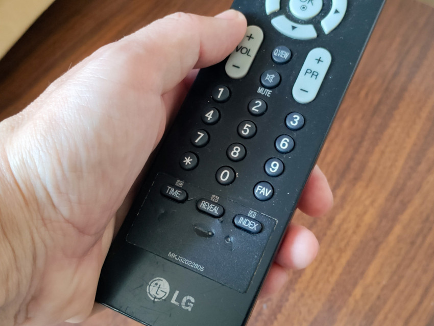 Пульт LG в руке пользователя, нижняя часть корпуса