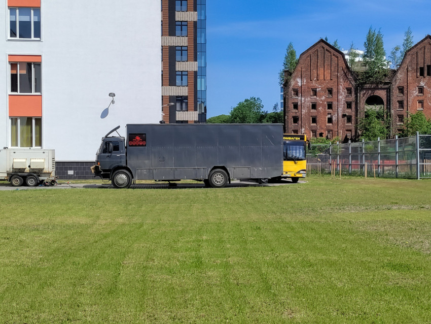 Технический фургон съемочной группы на фоне старого кирпичного здания